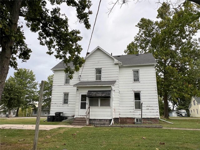 view of front facade with a front yard and central air condition unit