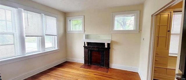 interior details featuring a brick fireplace and hardwood / wood-style floors