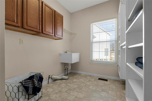 laundry area with cabinets and sink