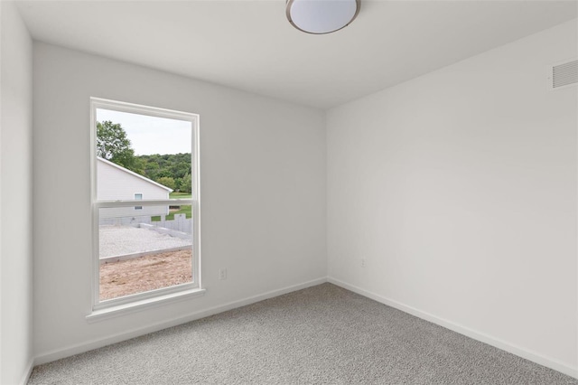 unfurnished room featuring baseboards, visible vents, and carpet floors