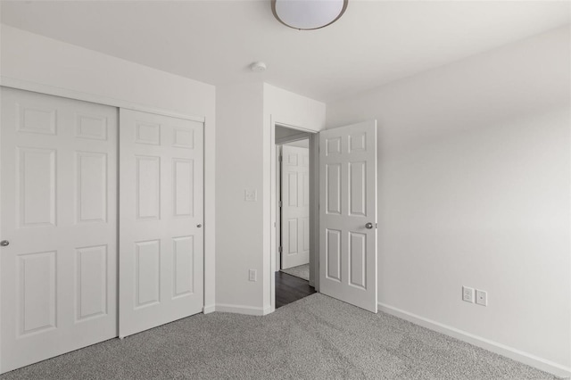 unfurnished bedroom with carpet flooring, baseboards, and a closet