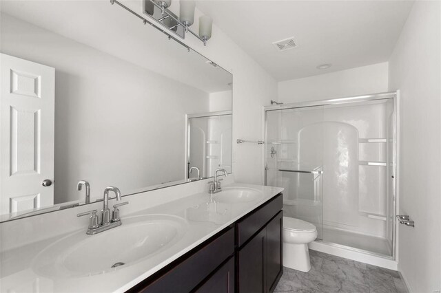 bathroom with vanity, toilet, and a shower with door