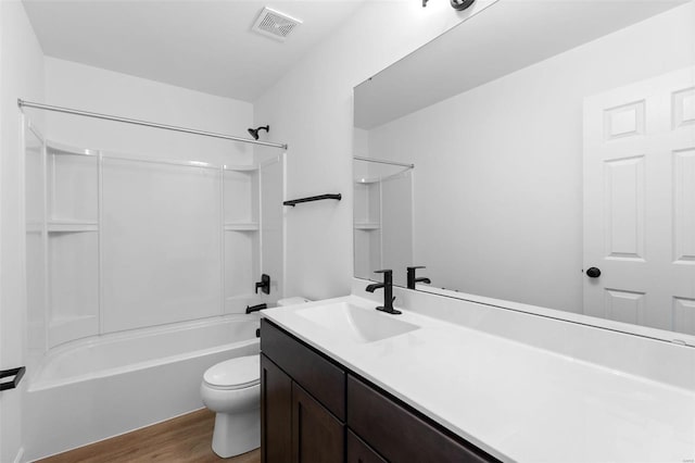 full bathroom featuring hardwood / wood-style flooring, bathing tub / shower combination, vanity, and toilet