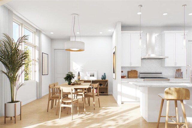 dining area with light hardwood / wood-style floors, a healthy amount of sunlight, and sink