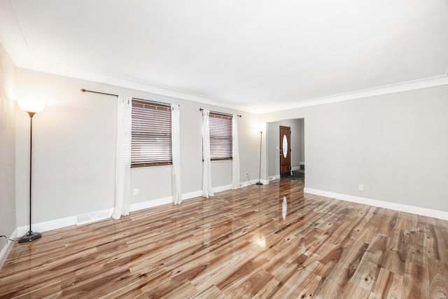 spare room with wood-type flooring and ornamental molding