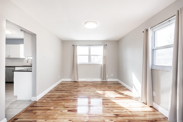 empty room with sink and light wood-type flooring