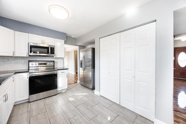 kitchen featuring white cabinetry, decorative backsplash, and stainless steel appliances