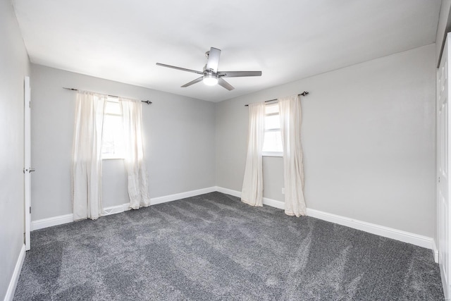 spare room featuring ceiling fan and dark colored carpet