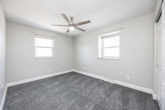 carpeted empty room with ceiling fan and plenty of natural light