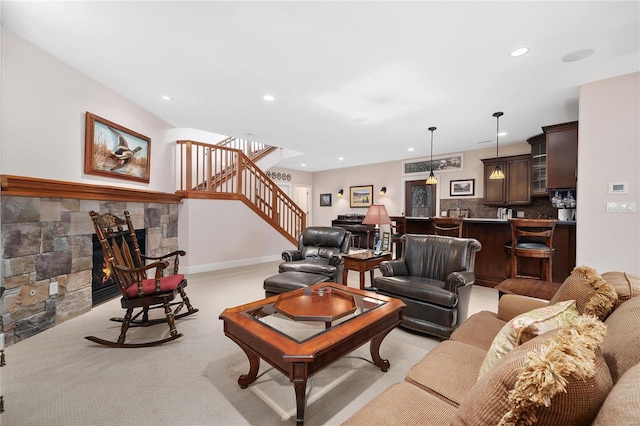 living room featuring a stone fireplace and light carpet