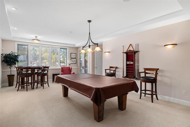 game room featuring light carpet, a tray ceiling, and pool table