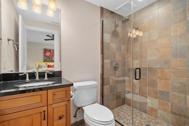 bathroom with ceiling fan, vanity, toilet, and an enclosed shower