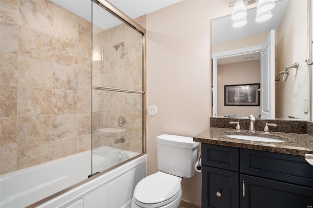 full bathroom with bath / shower combo with glass door, toilet, and vanity