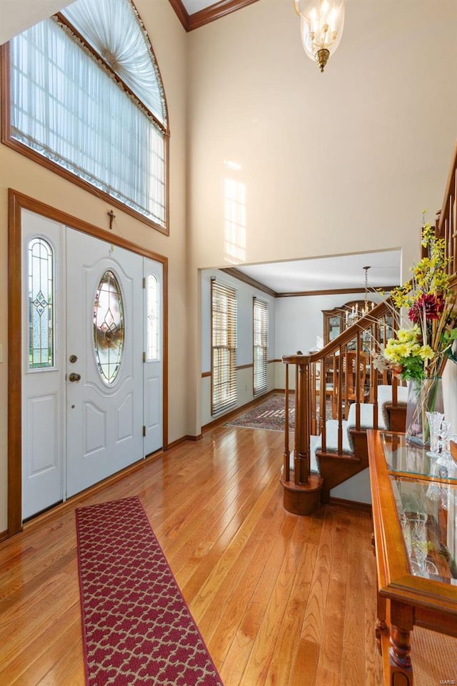 entrance foyer with light hardwood / wood-style flooring, plenty of natural light, and ornamental molding