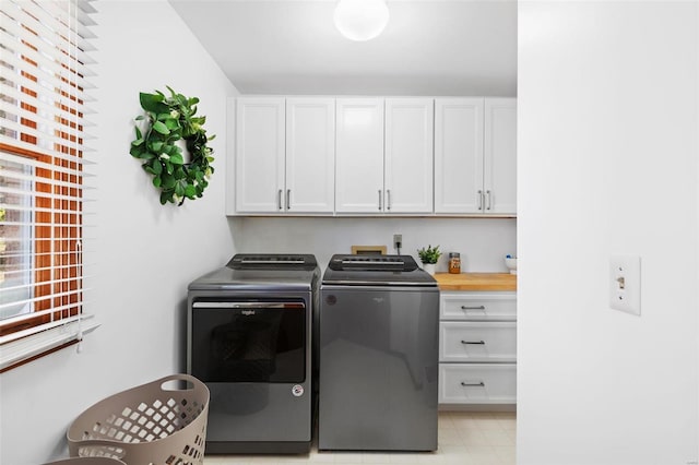 laundry area with washing machine and clothes dryer and cabinets