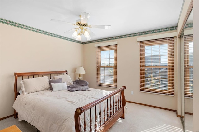 bedroom with light carpet, multiple windows, and ceiling fan