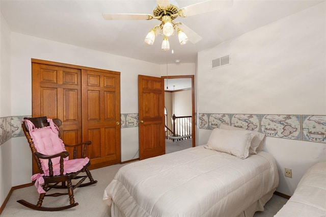 carpeted bedroom with ceiling fan and a closet