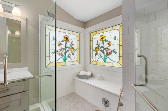 bathroom featuring tile patterned floors, a shower with shower door, and vanity