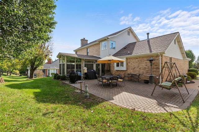 back of house featuring a sunroom, a yard, and a patio area