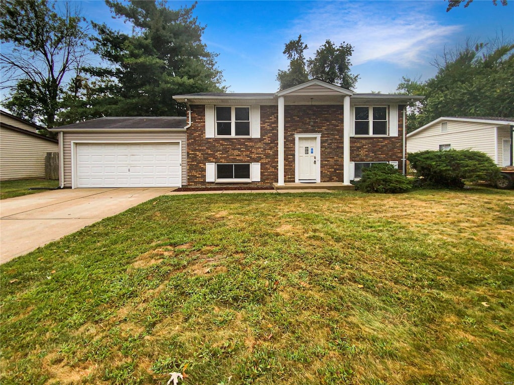 raised ranch with a front yard and a garage