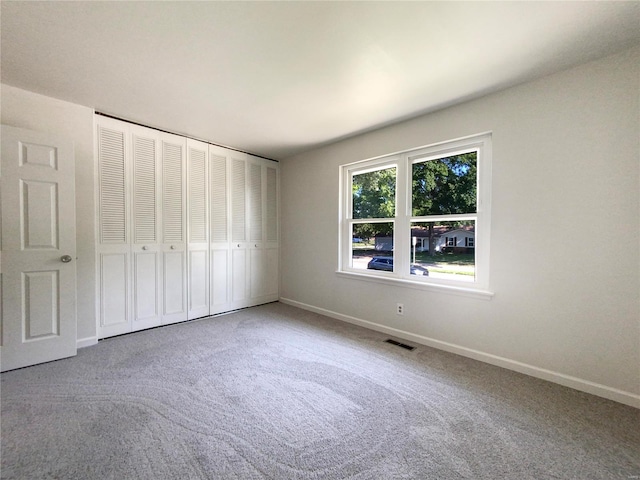 unfurnished bedroom featuring carpet flooring and a closet