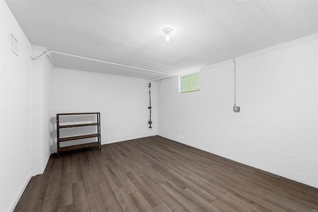 basement with dark hardwood / wood-style flooring and a textured ceiling