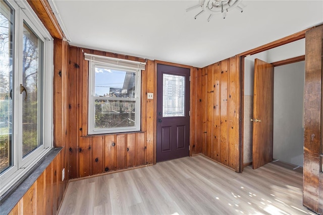 foyer entrance featuring wooden walls and light hardwood / wood-style flooring