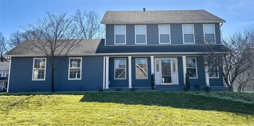 view of front of property featuring a front yard and roof with shingles