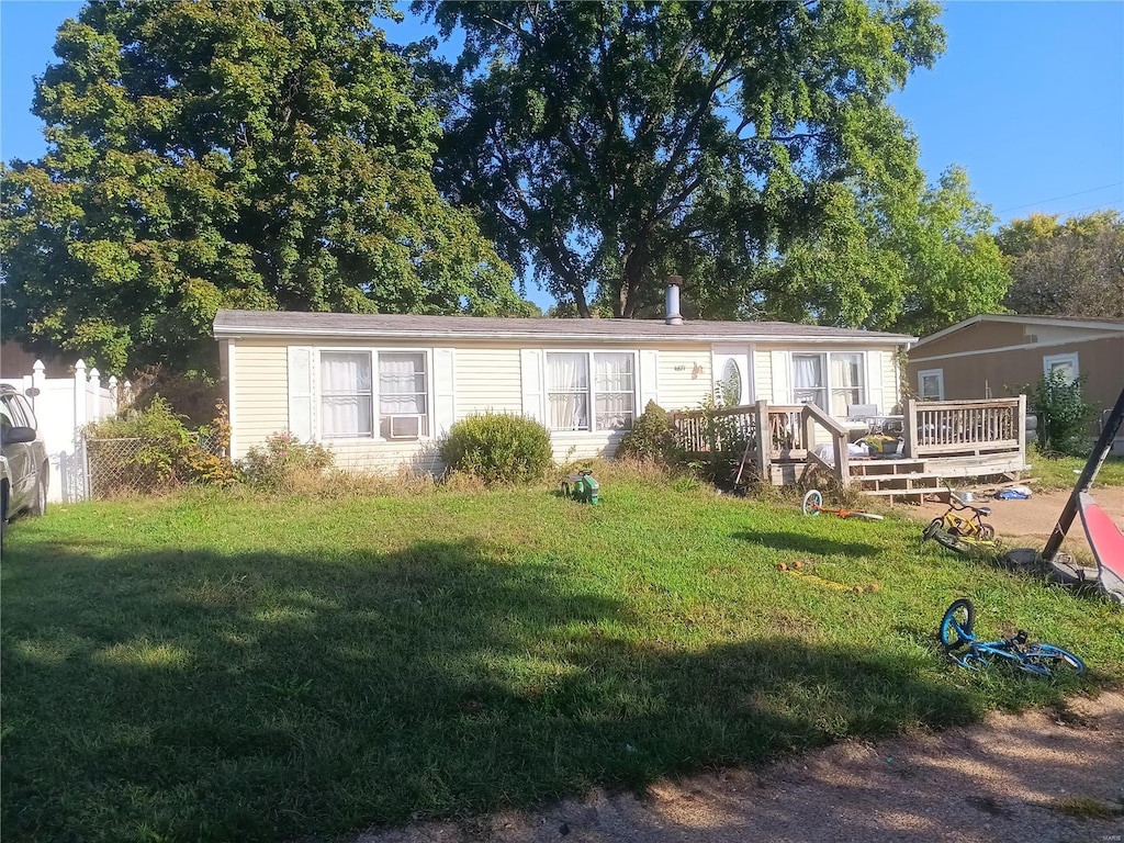 rear view of property featuring a deck and a lawn