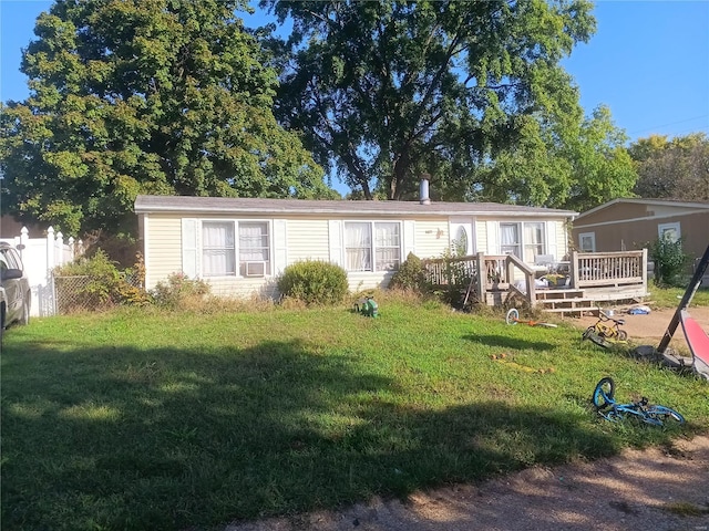 rear view of property featuring a deck and a lawn