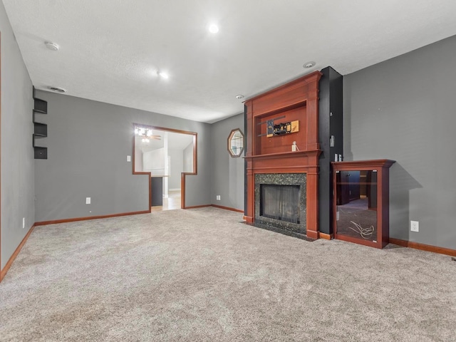 unfurnished living room featuring a textured ceiling, carpet flooring, and a tile fireplace