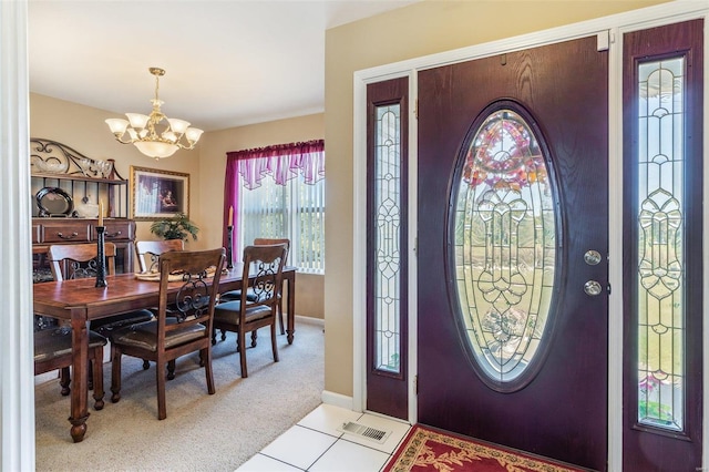 carpeted entryway with a notable chandelier