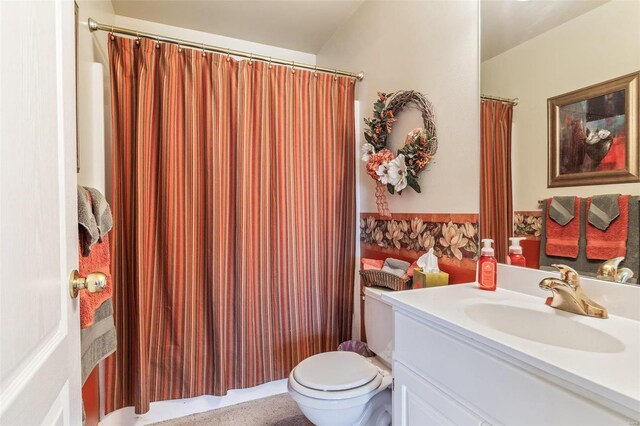 bathroom featuring a shower with shower curtain, vanity, and toilet