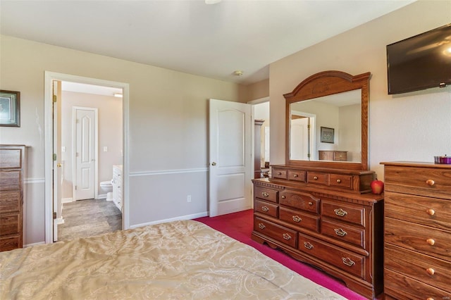 bedroom featuring dark colored carpet and connected bathroom