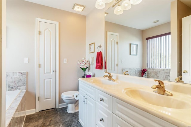 bathroom featuring vanity, tiled bath, and toilet