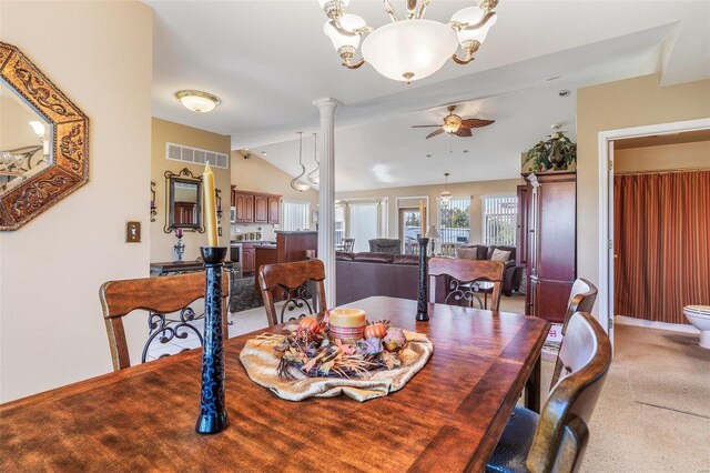 dining room featuring ceiling fan with notable chandelier, decorative columns, and lofted ceiling