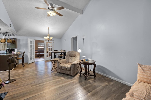 sitting room featuring french doors, dark hardwood / wood-style flooring, beamed ceiling, a textured ceiling, and ceiling fan with notable chandelier