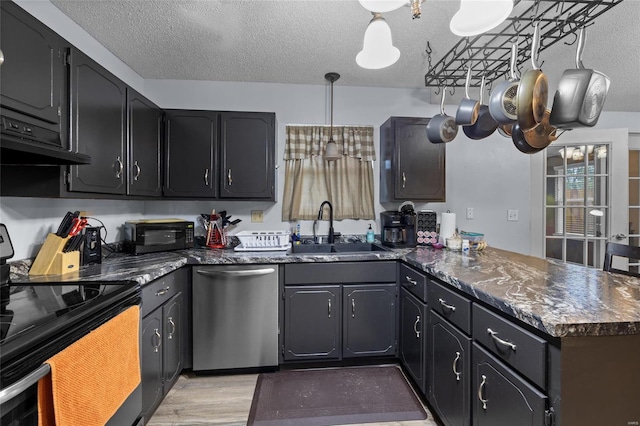 kitchen featuring sink, light hardwood / wood-style flooring, decorative light fixtures, a textured ceiling, and black appliances