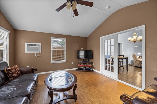 living room featuring wood-type flooring, ceiling fan with notable chandelier, vaulted ceiling, and a healthy amount of sunlight