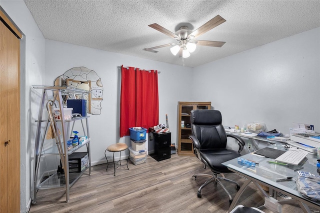 office space featuring a textured ceiling, light hardwood / wood-style flooring, and ceiling fan