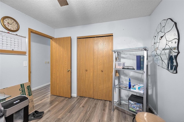 interior space featuring hardwood / wood-style floors, ceiling fan, and a textured ceiling