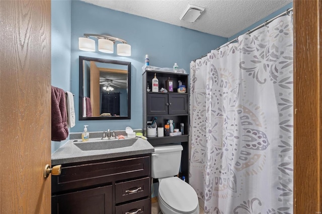 bathroom with vanity, a textured ceiling, toilet, and ceiling fan