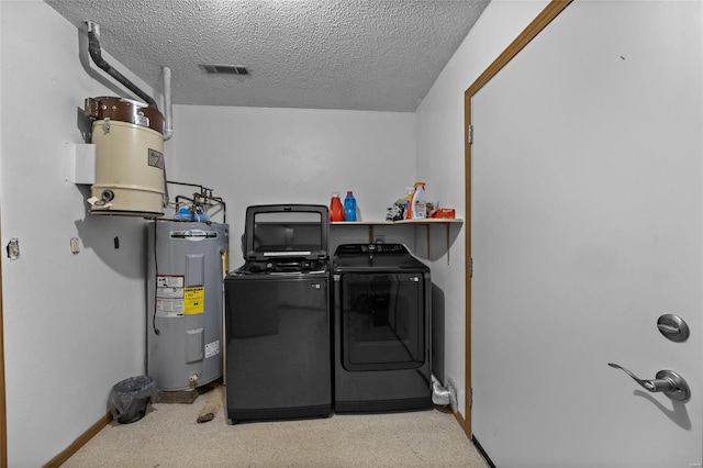 clothes washing area featuring electric water heater, separate washer and dryer, a textured ceiling, and light carpet