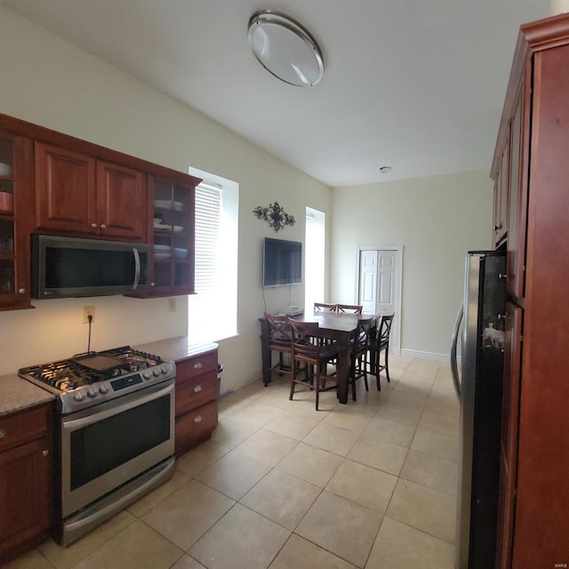 kitchen with light tile patterned floors and stainless steel appliances