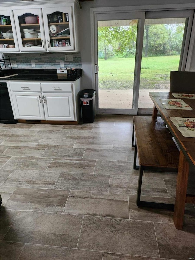 kitchen with white cabinets, backsplash, and a wealth of natural light