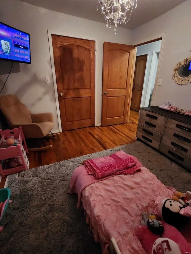 bedroom featuring a notable chandelier and light hardwood / wood-style floors