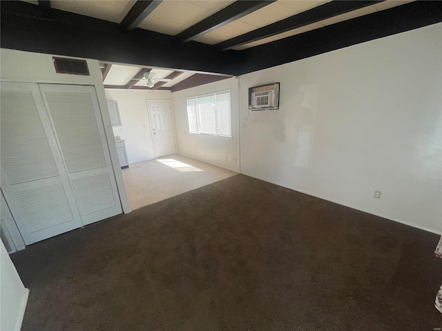 carpeted spare room with beamed ceiling and a wall mounted air conditioner