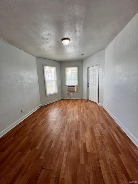 unfurnished room featuring wood-type flooring and a textured ceiling