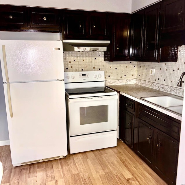 kitchen featuring wall chimney exhaust hood, light wood-type flooring, white appliances, and sink