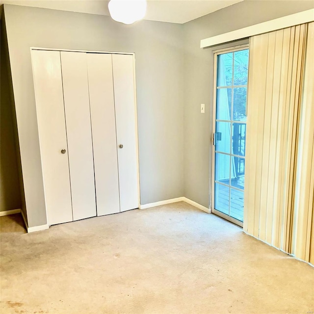 unfurnished bedroom featuring light carpet and a closet